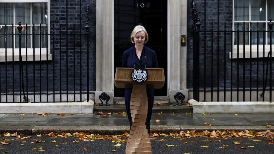 Liz Truss steht vor Downing Street Number 10. Sie schaut auf ein Rednerpult hinunter.