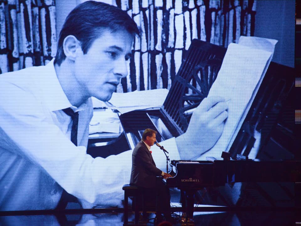 Udo Jürgens am Piano, im Hintergrund ein Bild aus jungen Jahren.