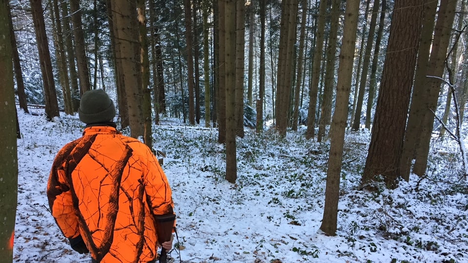 Jäger wartet im verschneiten Wald