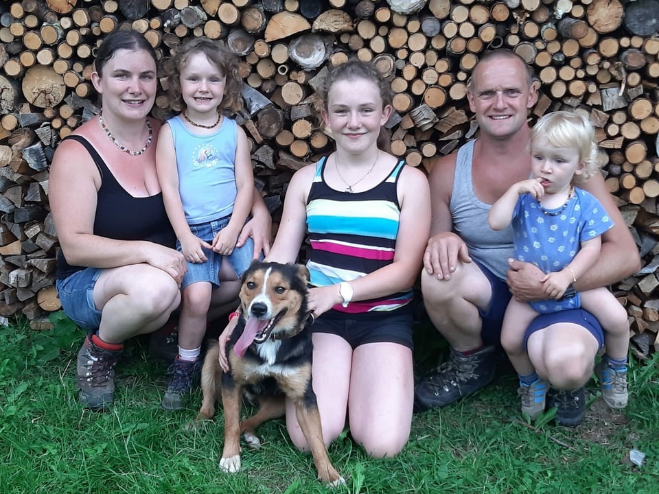 Familienfoto vor einer Holzwand.