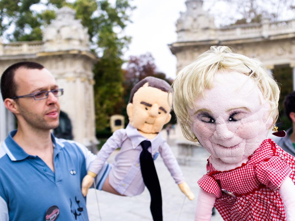 Eine Theatergruppe führt ein kritisches Puppenspiel auf mit Figuren, die spanischen Politikern gleichen.