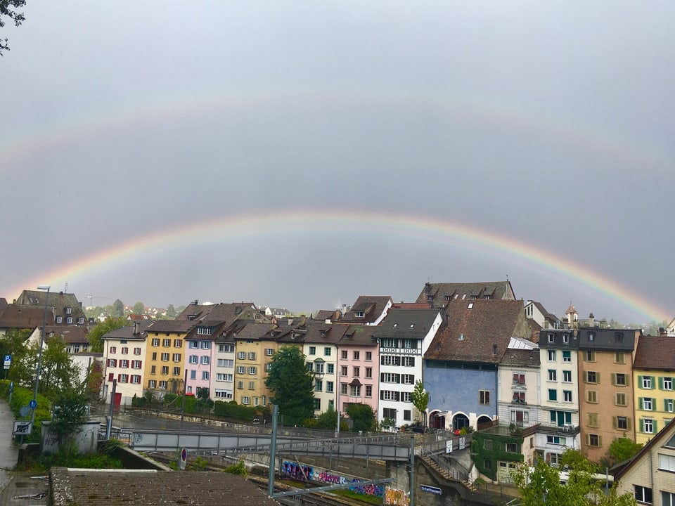 Das wechselhafte Aprilwetter zauberte über Schaffhausen einen doppelten Regenbogen her. Unter den Regenbögen sieht man die farbigen Häuser von Schaffhausen.