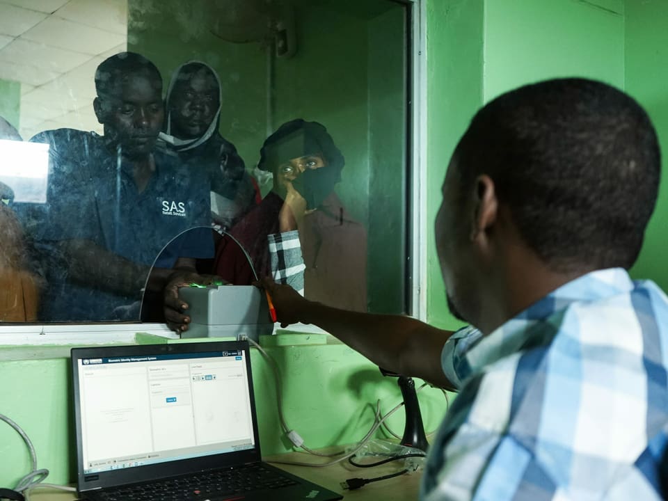 Ein Mann verifiziert im Lager Dadaab in Kenia seine Identität an einem Fingerabdruck-Scanner.