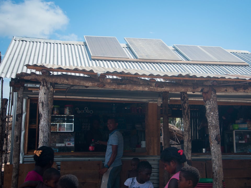 Eine Hütte mit Wellblechdach und Solarzellen.