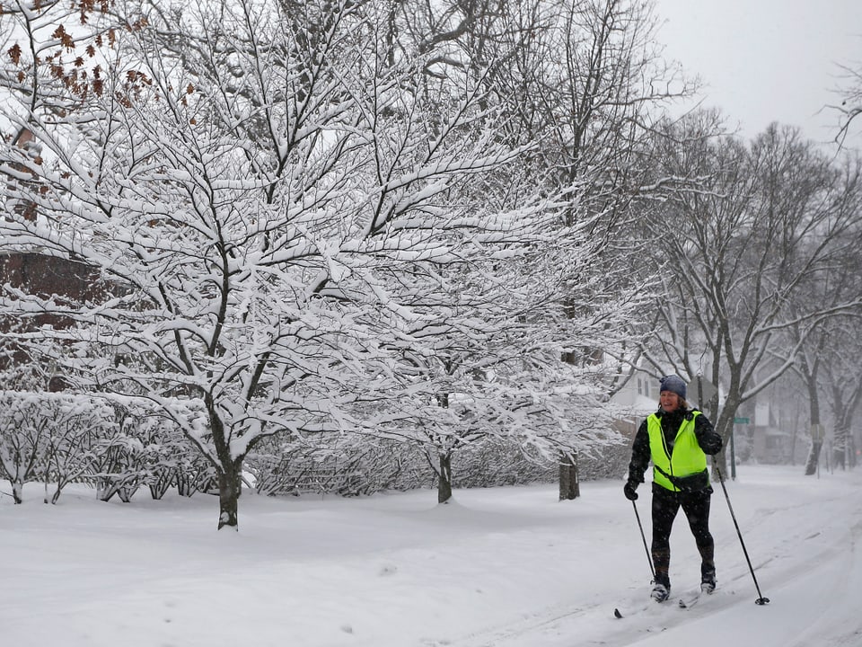 Eine Frau fährt mit den Langlauf-Skiern durch einen verschneiten Park in Chicago. 