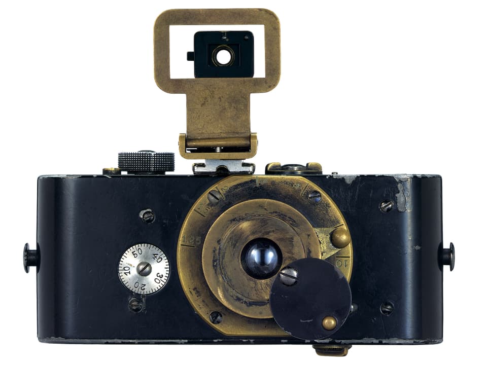 Eine Kamera aus schwarzem und goldenem Metall. 