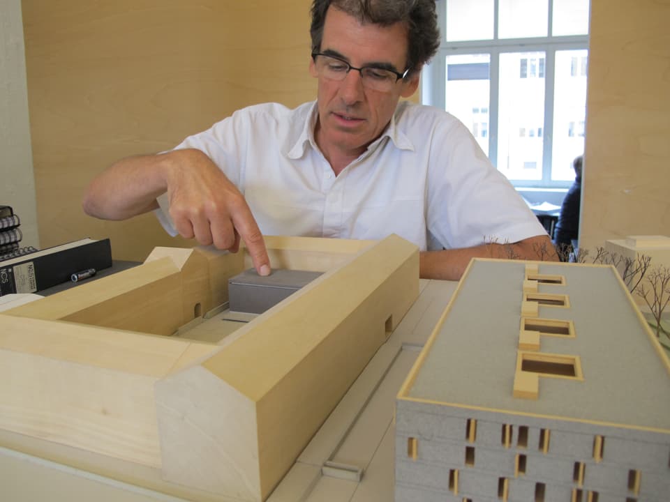 Schmidlin zeigt mit dem Finger auf den kleinen grauen Bau in der Mitte des Modells: Dort steht das Restaurant Spedition.