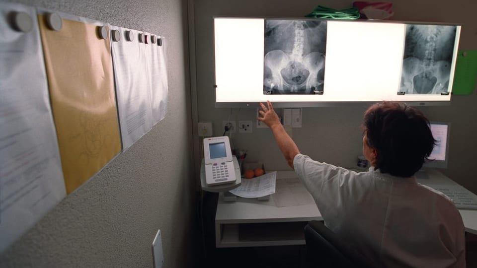 Eine Urologin betrachtet Röntgenaufnahmen.