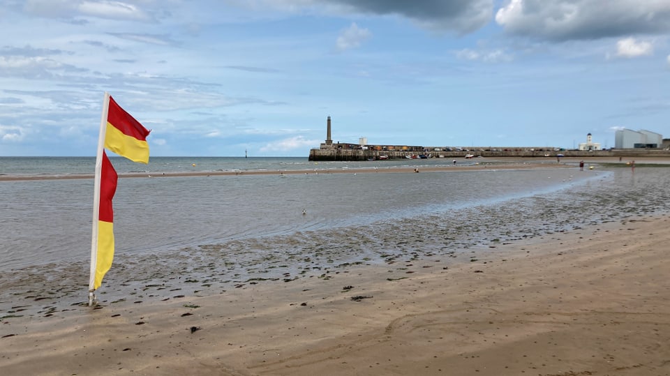 Beach, pier in the distance.