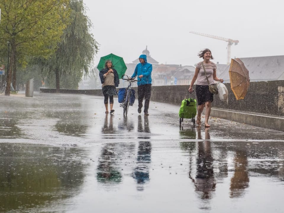 Personen mit Schirm im Regen
