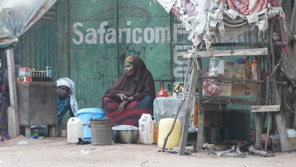 Frau sitzt vor einer Hütte im Flüchtlingslager Dadaab in Kenia.