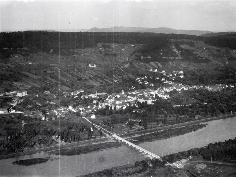 Ein Dorf an einem Fluss aus der Luft fotografiert.