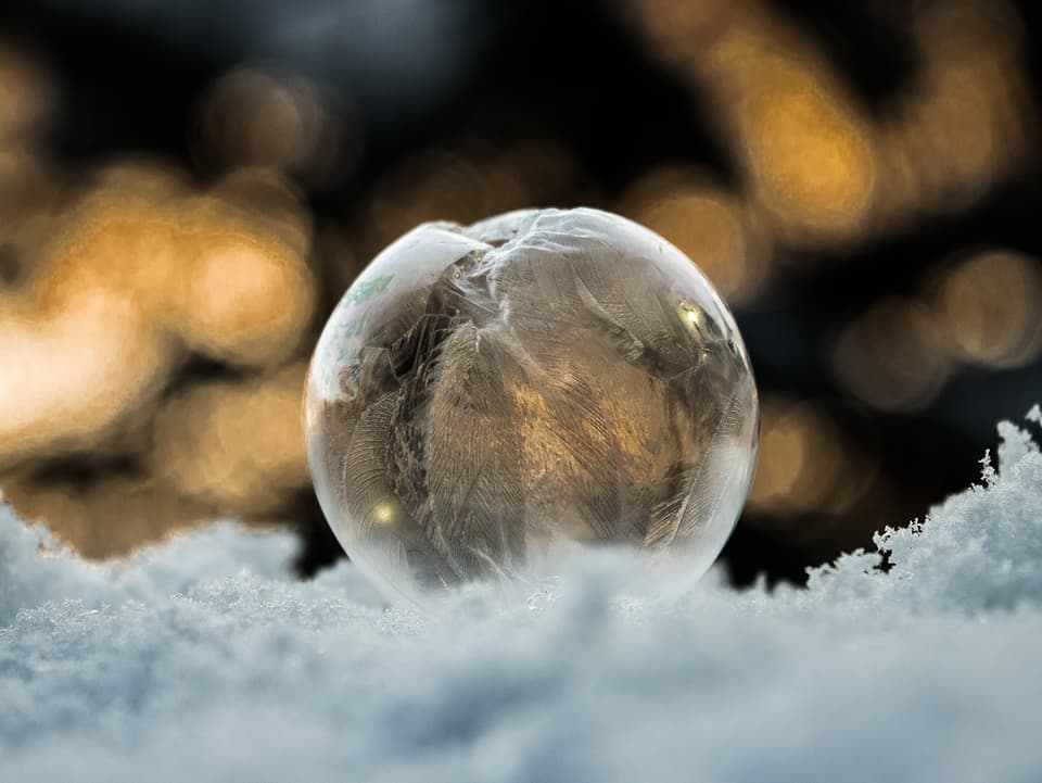 Eine gefrorene Seifenblase auf Schnee.
