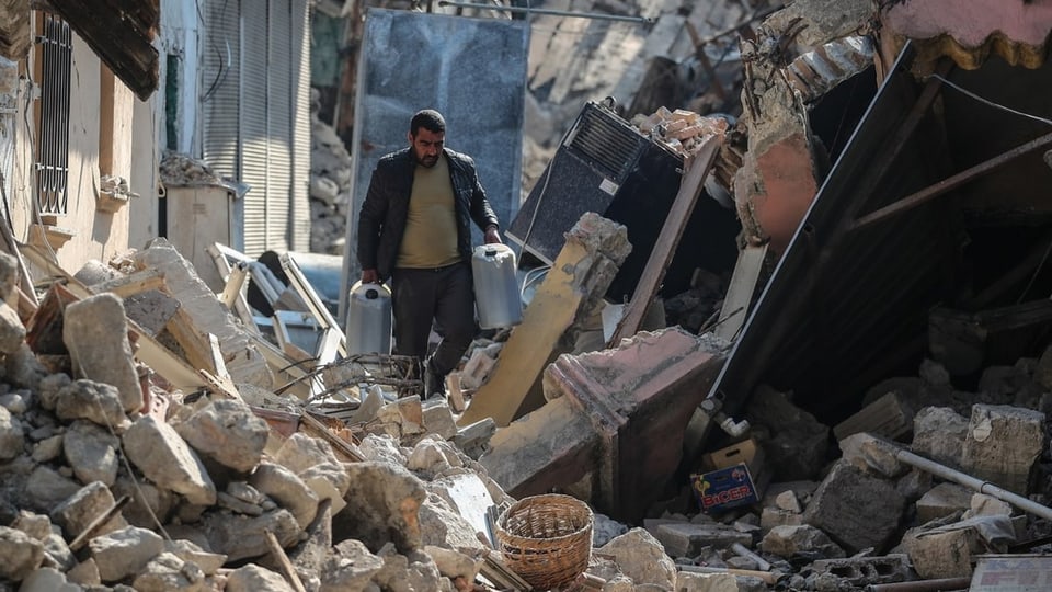 Ein Mann geht durch Trümmer der Erdbeben.
