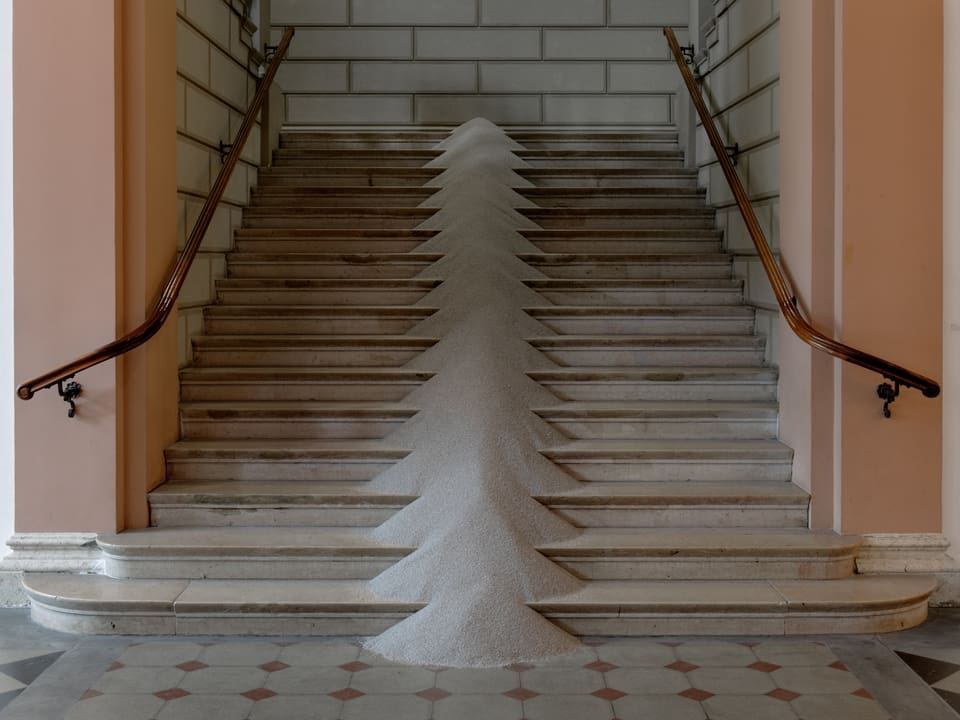 Eine Treppe, in deren Mitte Sand aufgehäuft ist. 