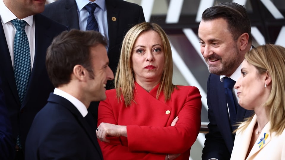 Leaving behind a talkative Macron, Meloni's icy appearance comes in a red blazer in the middle.