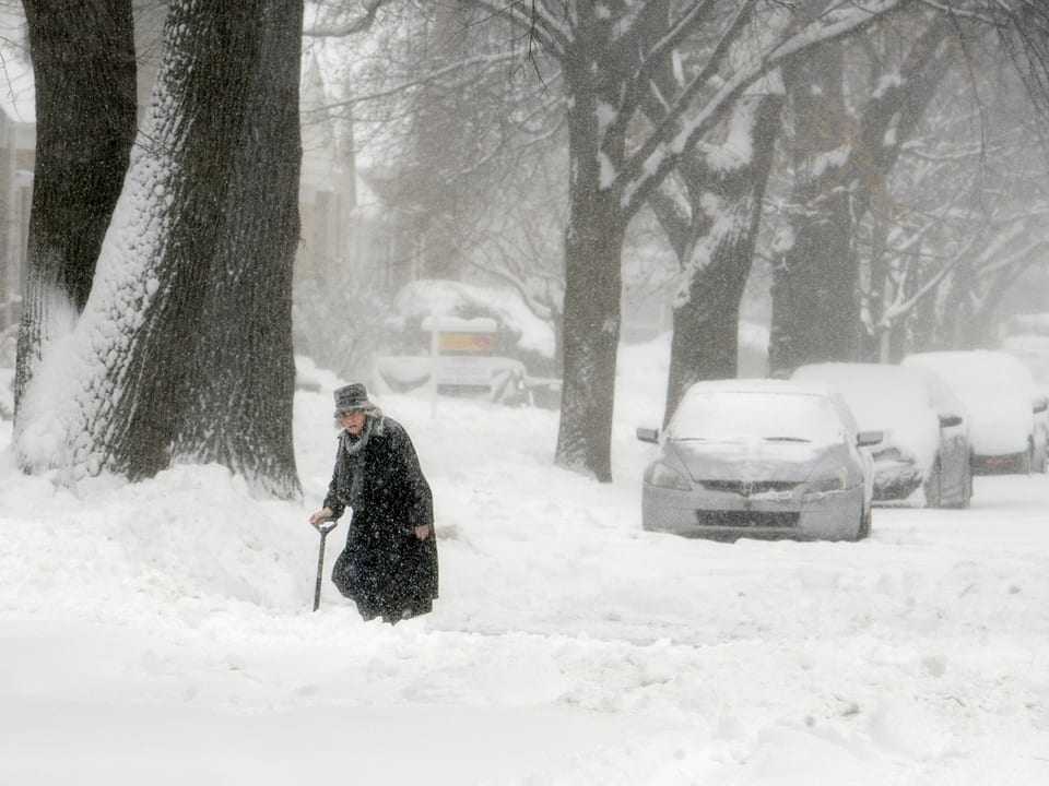 Eine Rentnerin stapft durch die schneebedeckten Strassen Chicagos. 