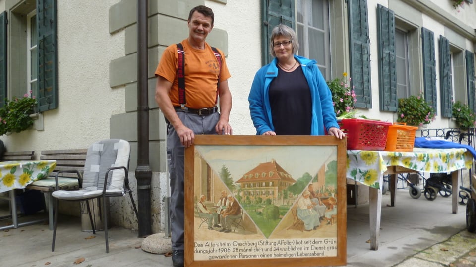 Meisterbauer Meinrad Ackermann und Heimleiterin Pia Zwahlen vor dem Oeschberg - mit einem Bild aus früheren Zeiten