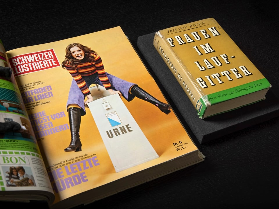 Bild einer Zeitschrift mit einer Frau darauf, die über einen Urnenkasten springt und lacht. Daneben liegt ein Buch.