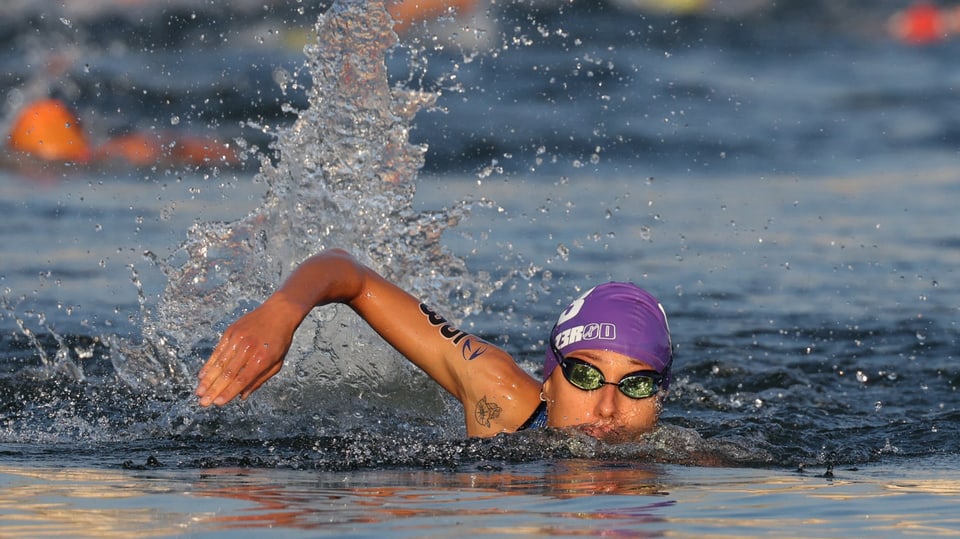 Eine Schwimerin schwing ihren rechten Arm aus dem Wasser