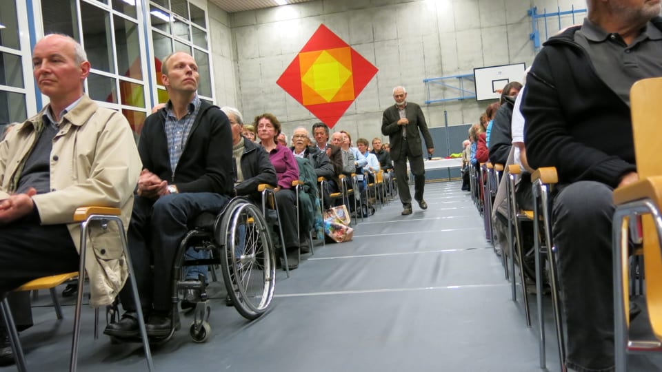 Zuschauer sitzen in der Turnhalle.