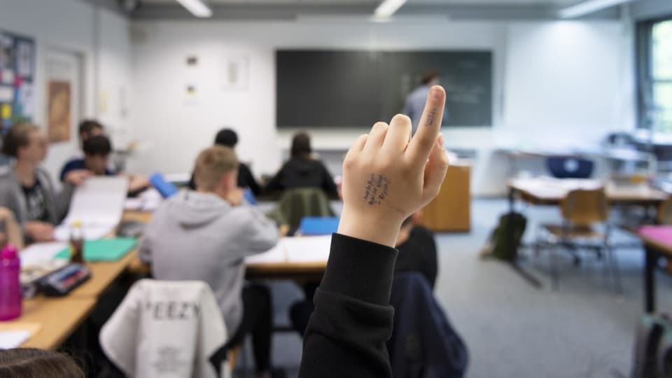 Sekundarschüler hebt die Hand im Unterricht.