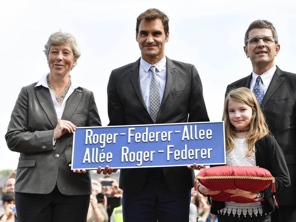 Roger Federer nimmt vom Bieler Stadtpräsidenten die Strassentafel mit seinem Namen entgegen.