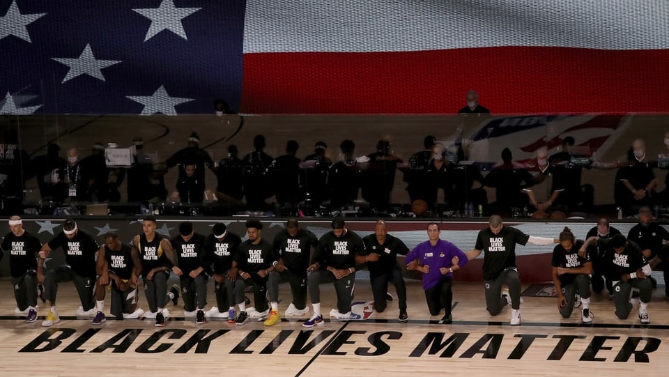 Die Spieler der Los Angeles Lakers knien, während die Nationalhymne gespielt wird.