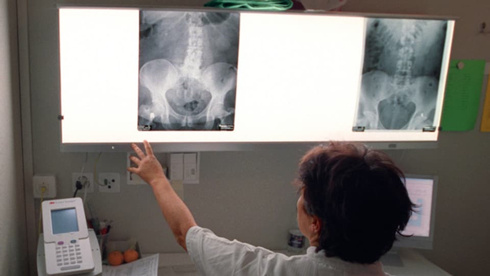 Eine Ärztin betrachtet ein Röntgenbild.