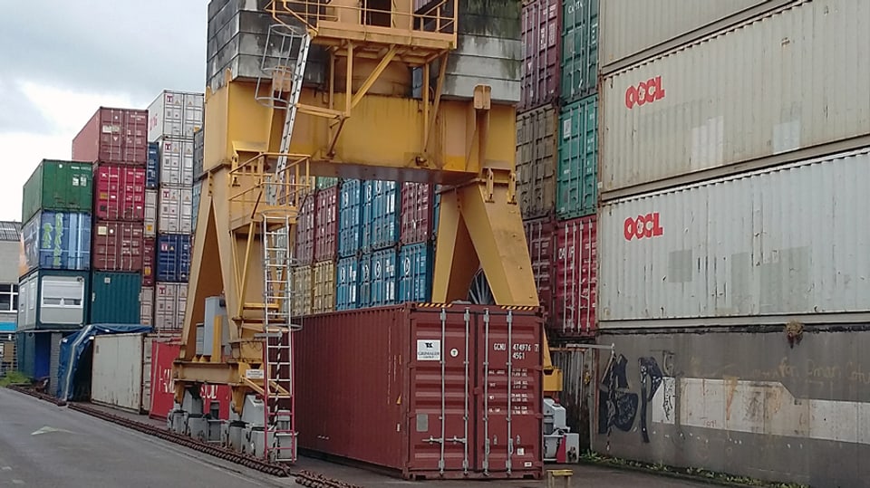 Gestapelte Container und ein Kran im Depot der Leimgruber AG in Basel.