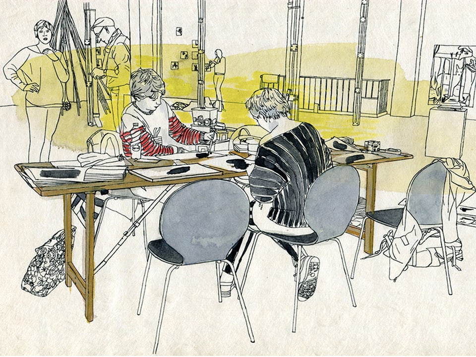 Zwei Frauen sitzen an einem Tisch, zeichnend.