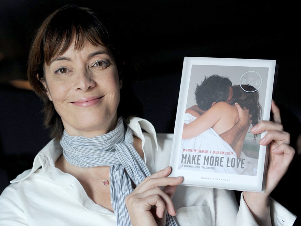 Ann-Marlene Henning hält ein Buch in der Hand, auf dem "Make more love" steht. 