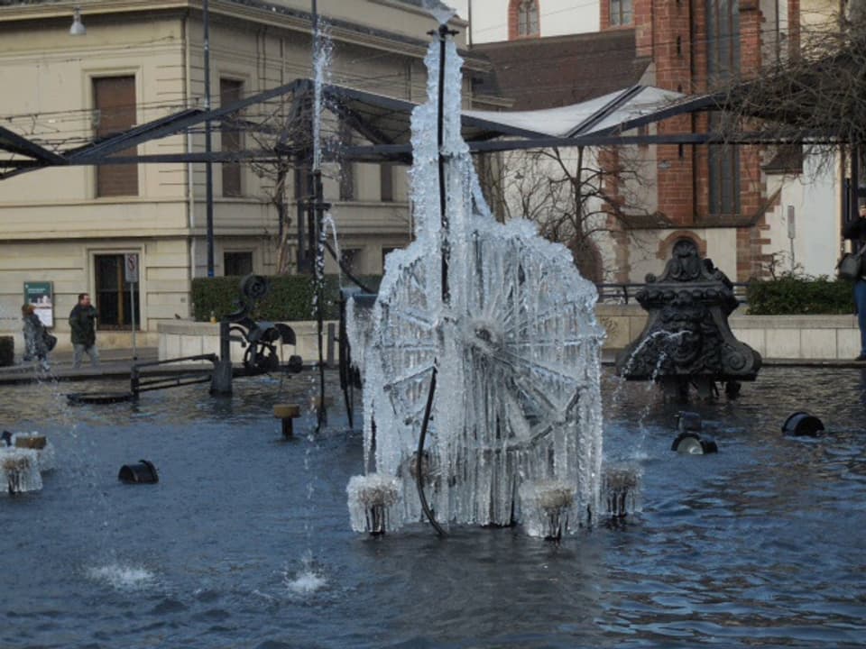 Das Wasserrad des Brunnens ist in Eis gehüllt.