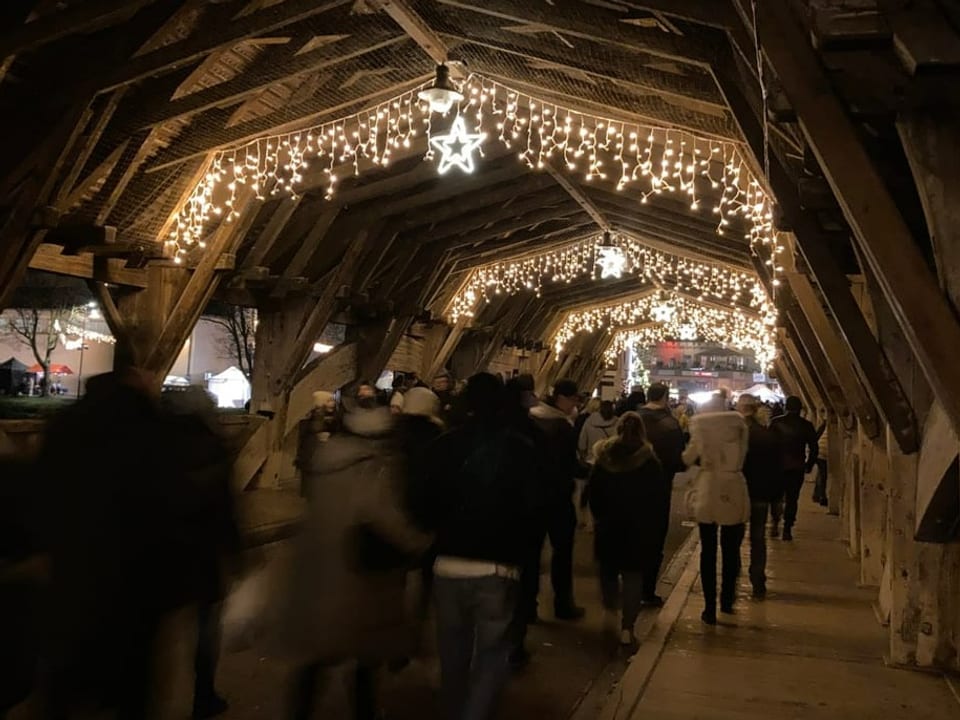 Fussgänger gehen über die Holzbrücke