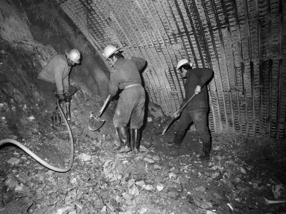 Männer schaufeln im Tunnel.