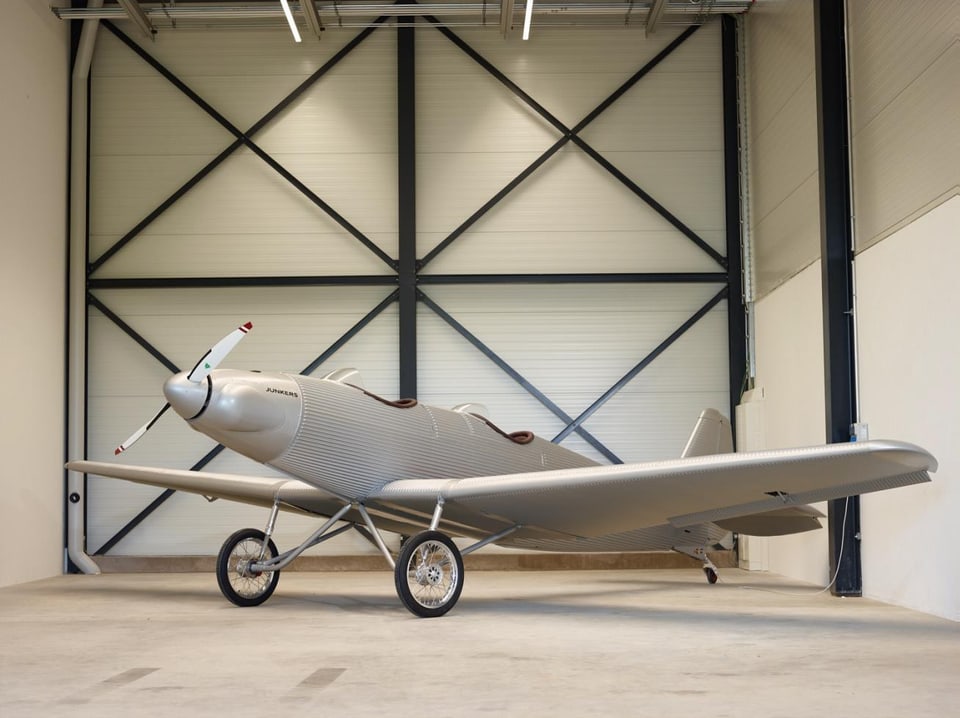 Eine Junkers A 50 Junior steht in einem Hangar. 