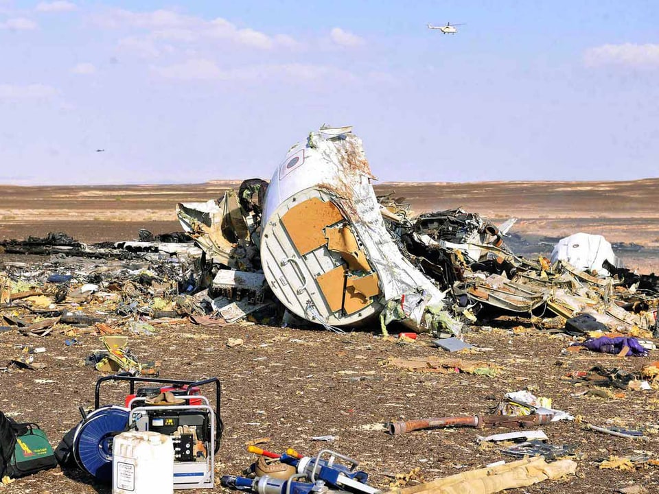 Die Überreste des Flugzeugs liegen verteilt im Sand.