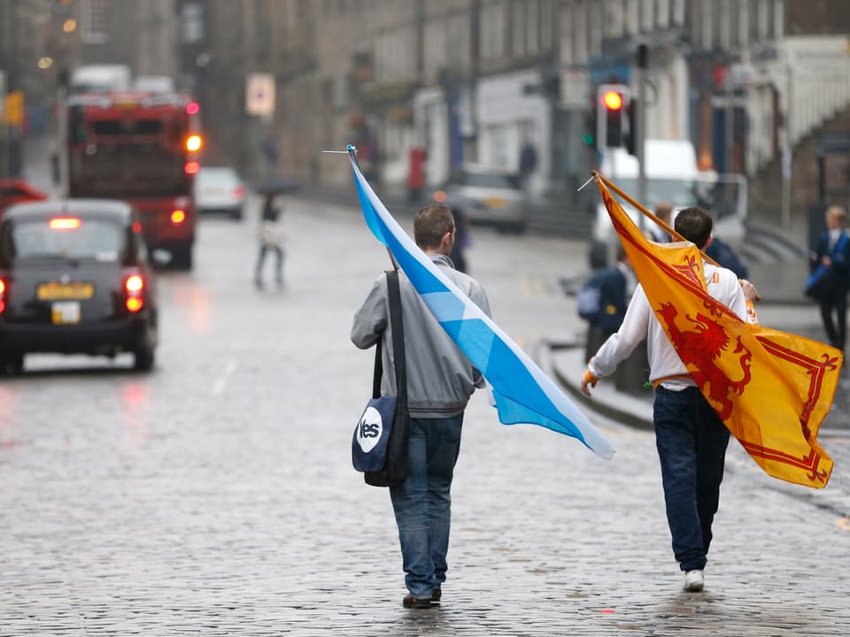 Zwei Befürworter der Unabhängigkeit tragen ihre Fahnen nach Hause. 