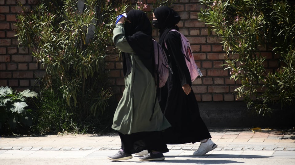Zwei junge Frauen tragen Abayas