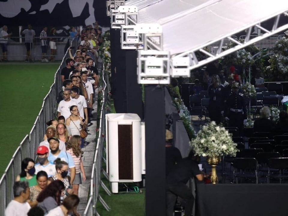 Fans stehen im Stadion an, wo Pelé in einem Zelt aufgebahrt ist.
