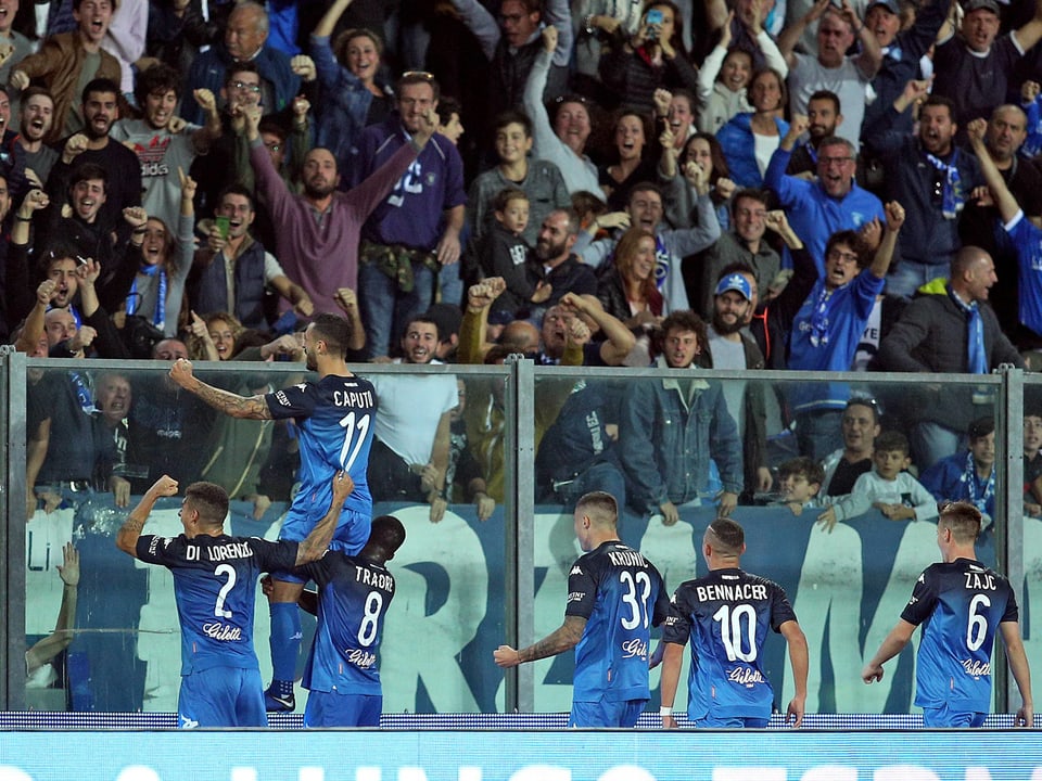 Spieler von Empoli klettern auf die Abschrankung, um mit den Fans zu feiern.