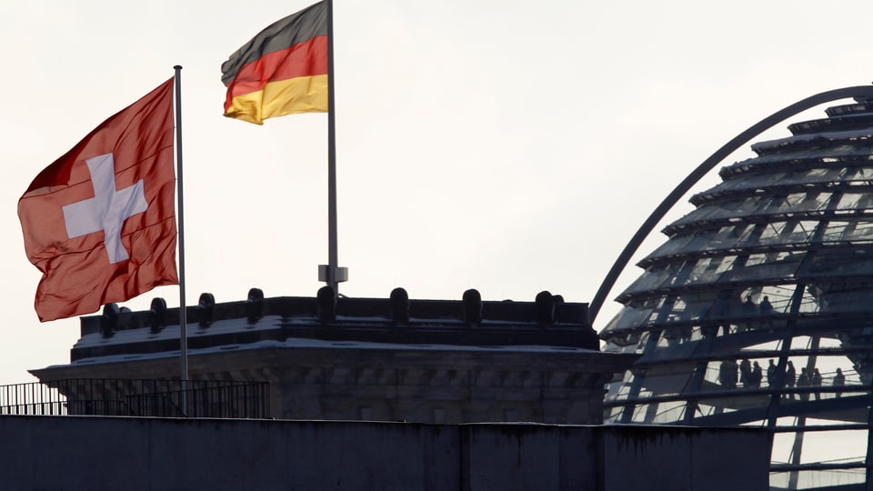 Die Schweizer Fahne weht vor der Deutschen Fahne in Berlin.