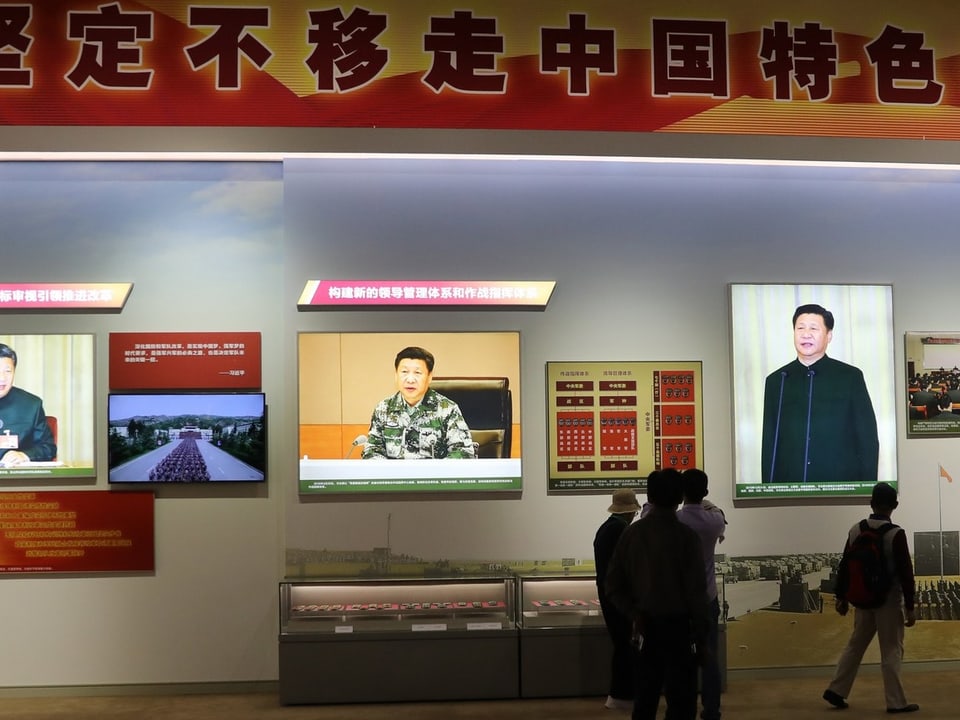 Besucher bewundern Bilder von Xi.