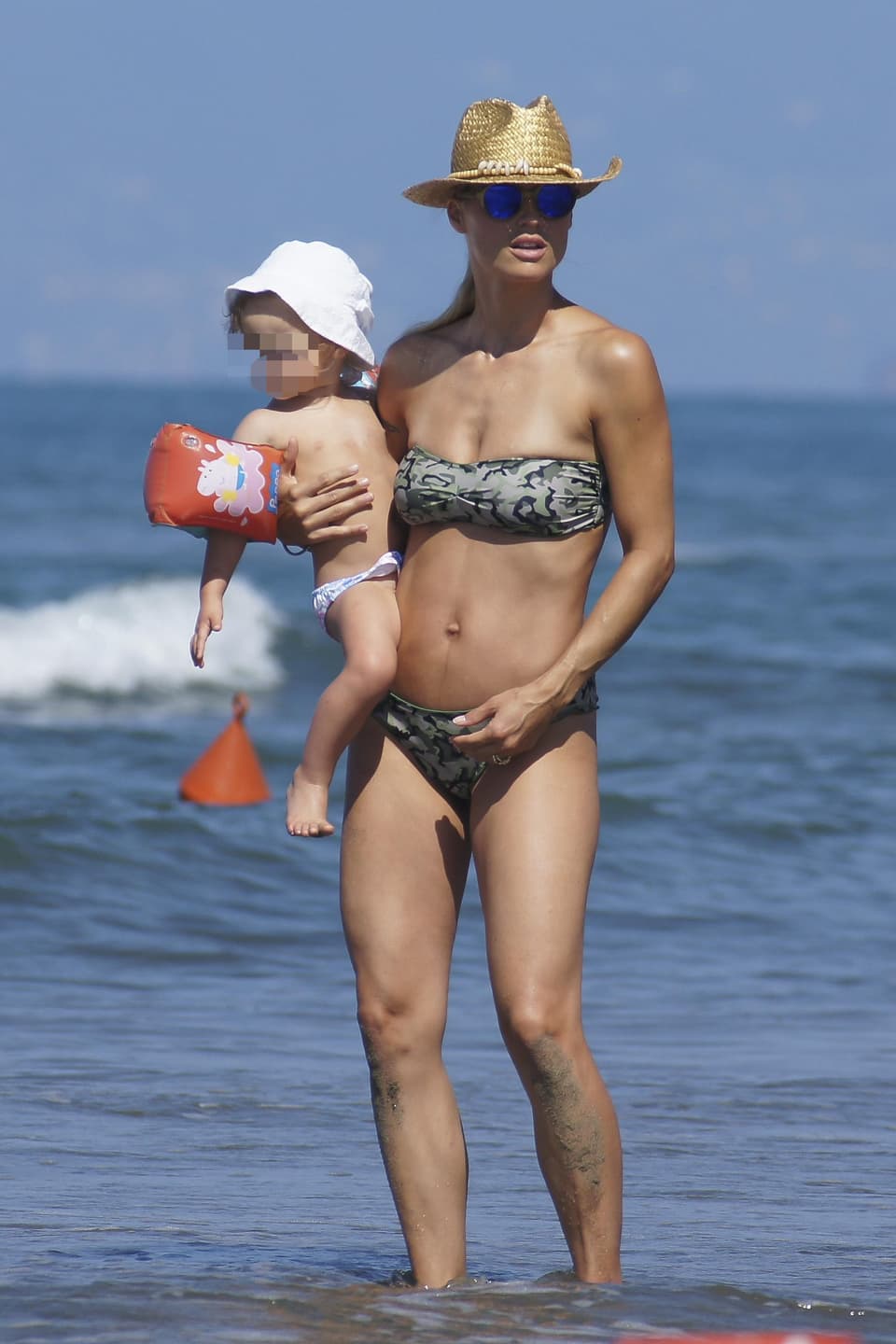 Michelle Hunziker mit ihrer Tochter Celeste im Arm am Strand.