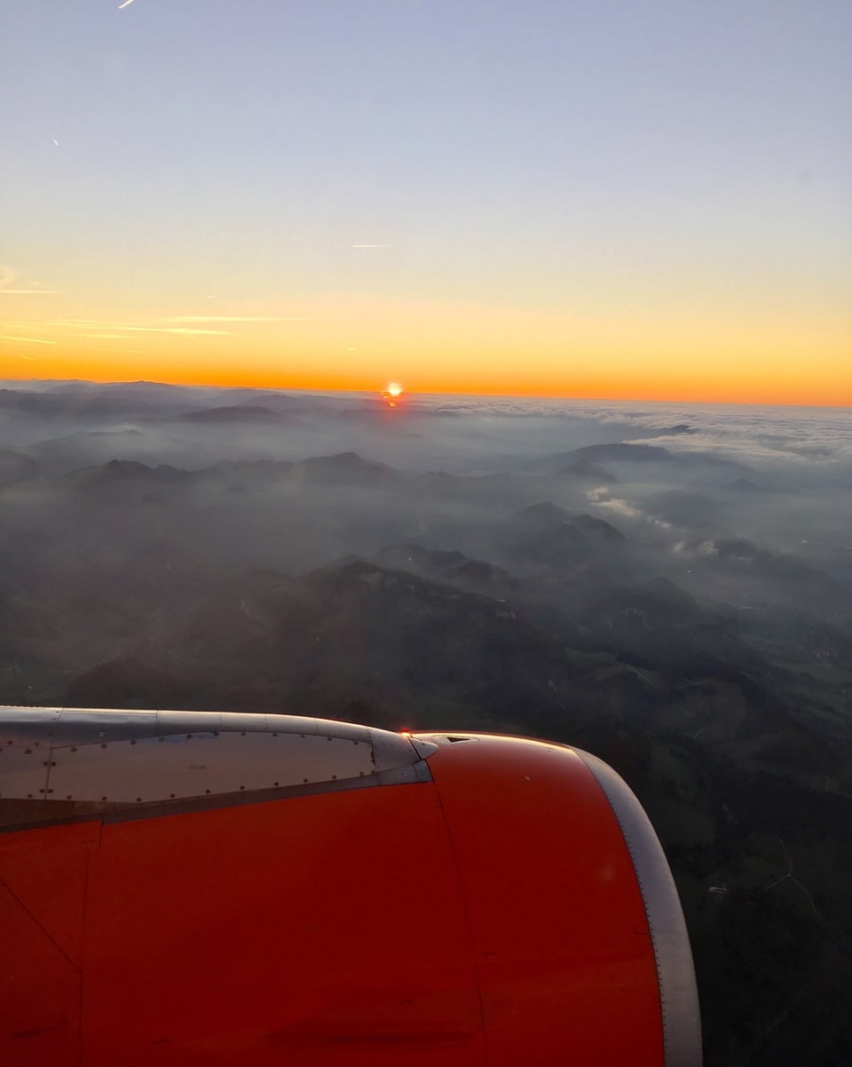 Blick aus dem Flugzeug auf das teils nebelüberzogene Land.