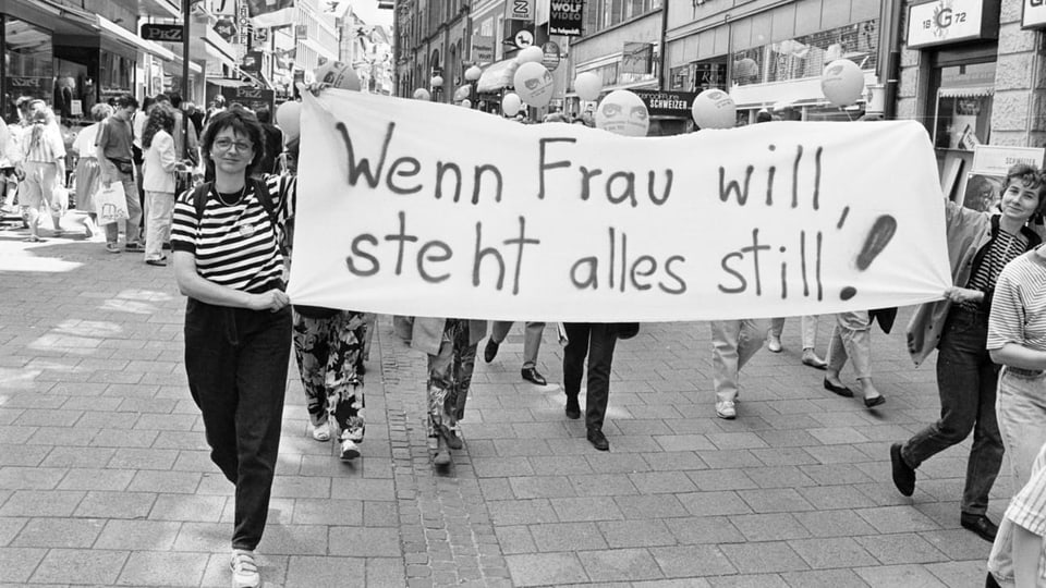 Zwei Frauen tragen ein Banner mit der Aufschrift: «Wenn Frau will, steht alles still.»