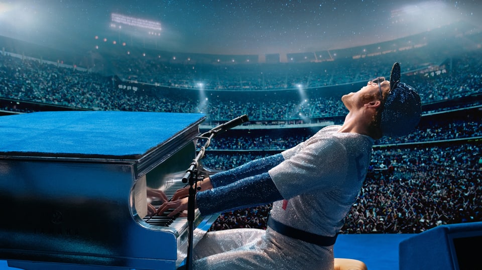 Taron Egerton als Elton John auf der Konzertbühne am Klavier.