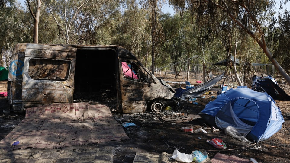 Ausgebrannter Lieferwagen und zerstörte Zelte nach einem Angriff auf ein Musikfestival.