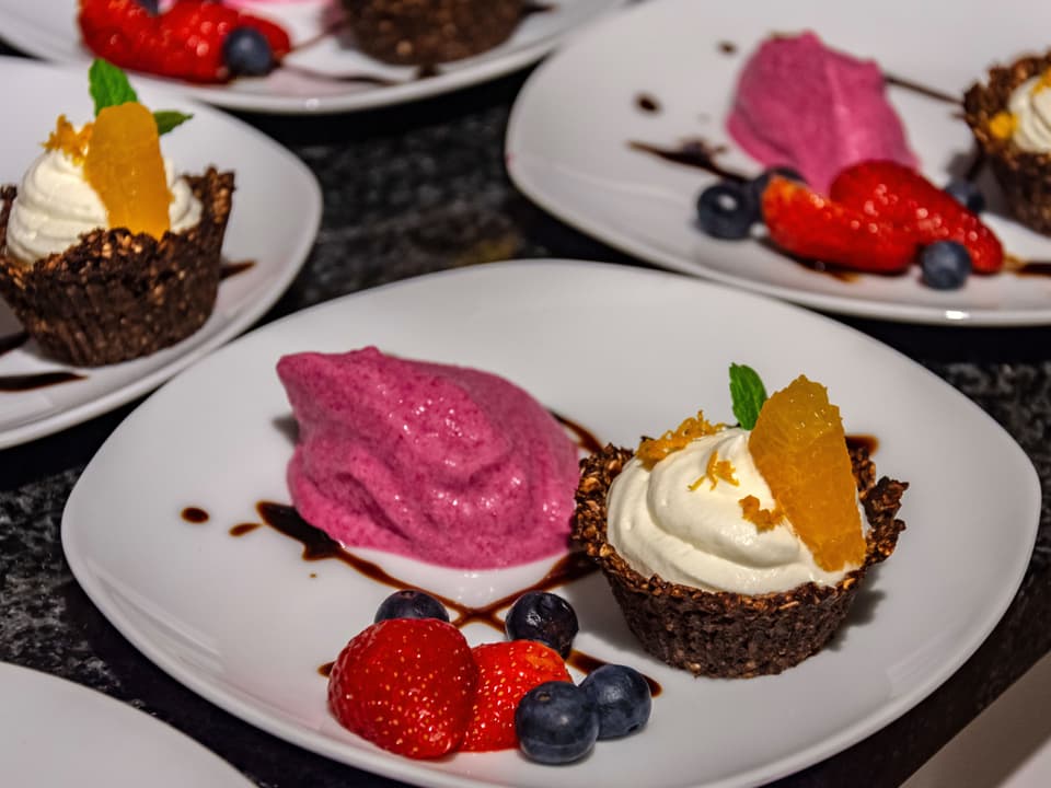 Ein Dessert-Teller mit Himbeer-pinkem Eis und einem Küchlein. 