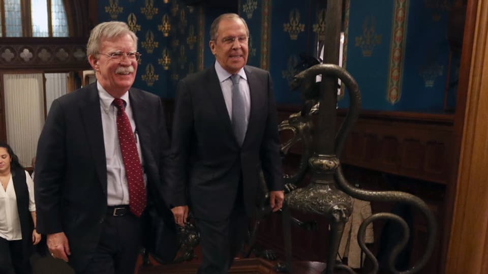 John Bolton und Sergei Lavrov gehen über einen Teppich